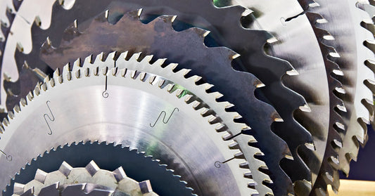 A storage rack full of circular saw blades. There are multiple saw blades in various sizes and teeth configuration.